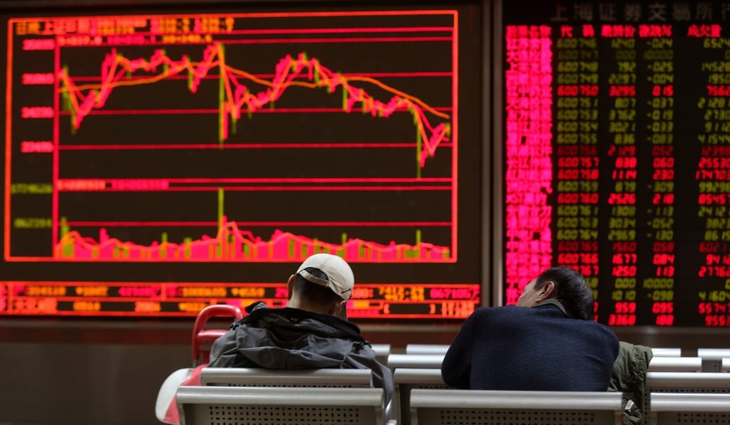 Chinese investors take a nap beside a large screen showing share prices at a securities brokerage house in Beijing. Photo: EPA