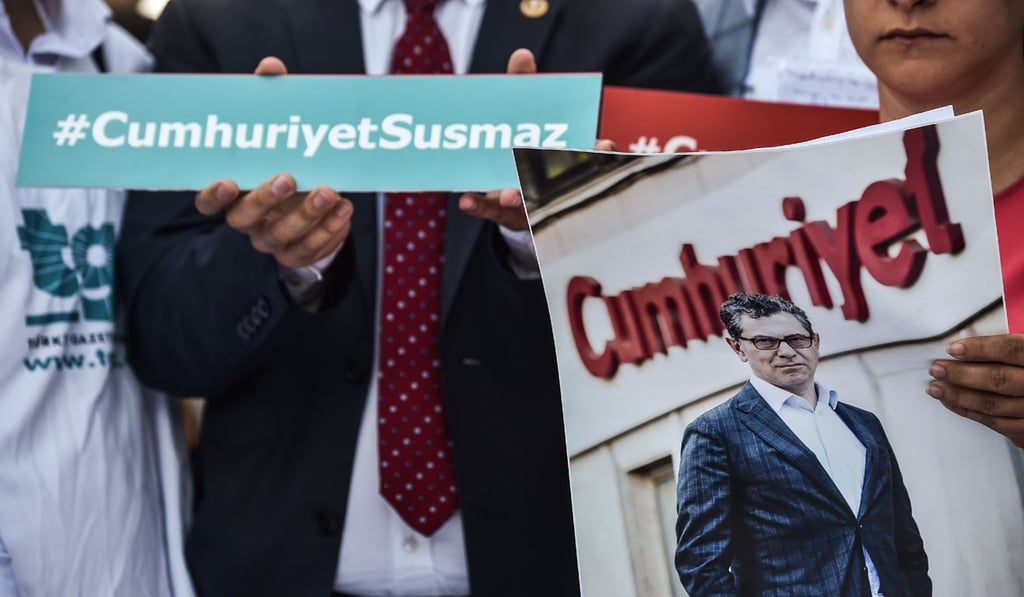 A man holds a portrait of jailed journalist Kadri Gursel. Photo: AFP