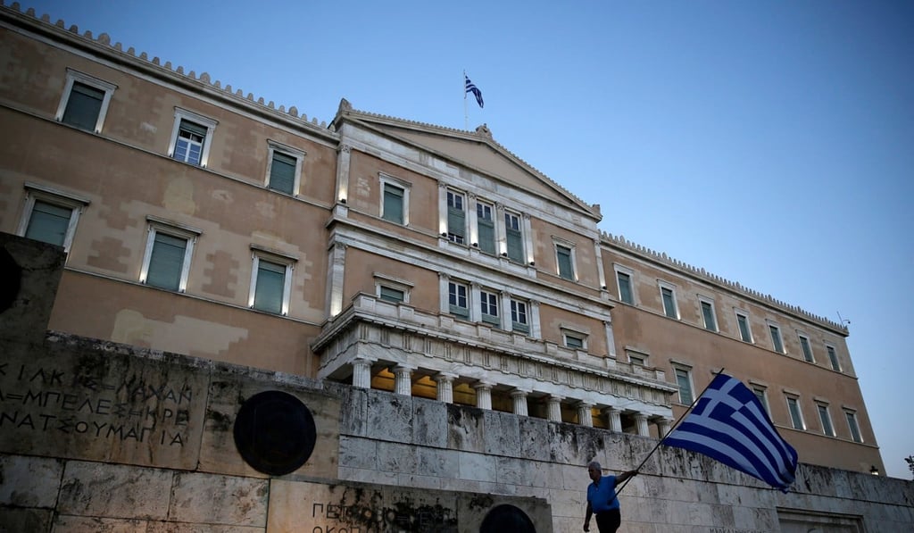 A man waves a Greek flag during an anti-goverment rally outside the Greek parliament building in Athens. Photo: Reuters