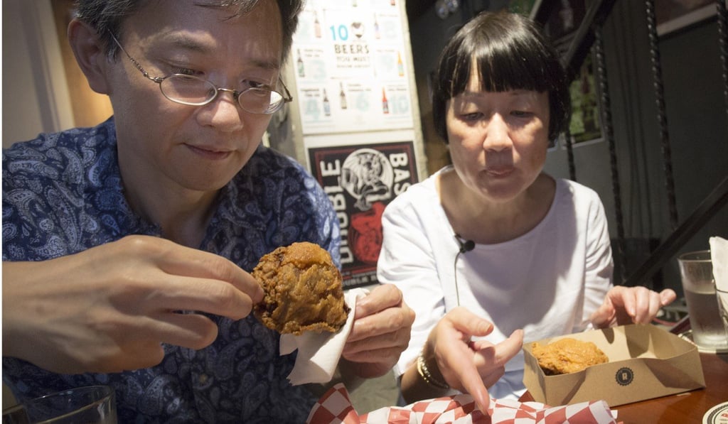 Post arts editor Kevin Kwong (left) and senior food and wine editor Susan Jung test the fried chicken at The Roundhouse in Wan Chai. Photo: May Tse