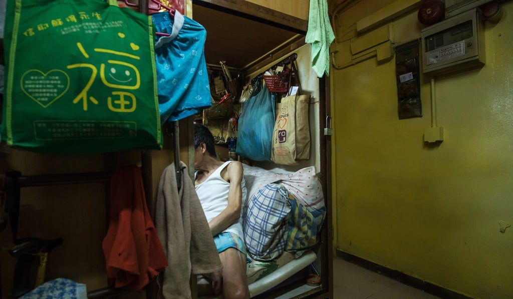 An occupant sits inside a subdivided residential unit. Photo: Paul Yeung/Bloomberg