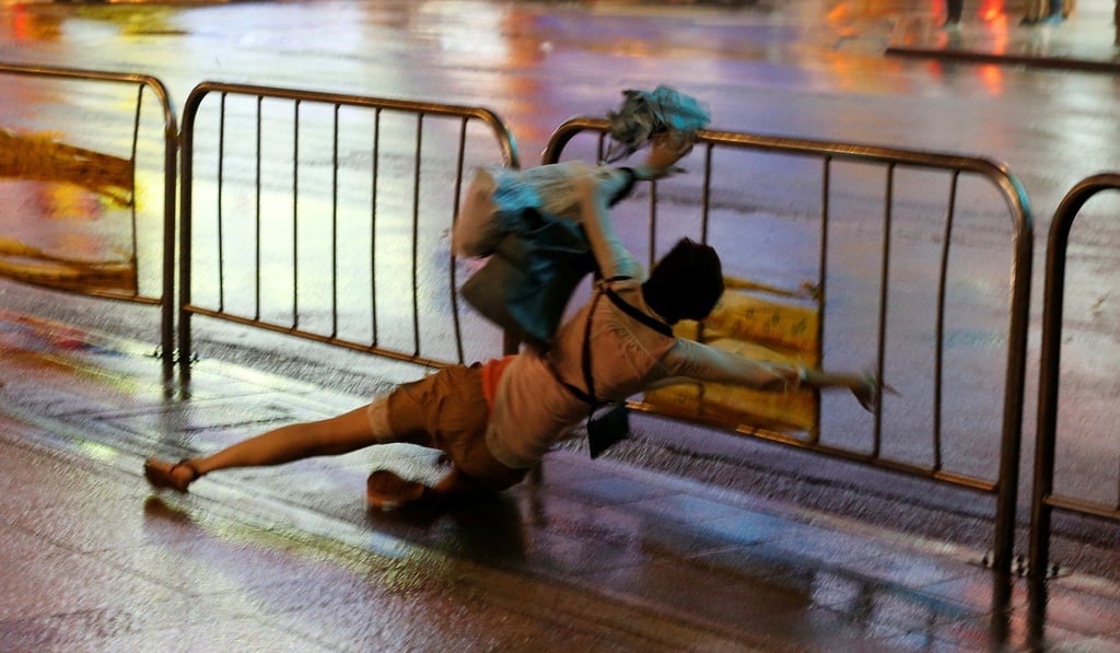 A woman falls as Typhoon Nesat hits Taipei on Saturday. Photo: Reuters