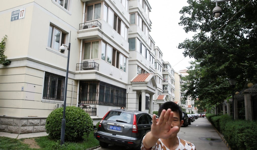 Plain-clothes security personnel try to stop a photographer from taking pictures of Liu Xia’s home in Beijing on July 14. Photo: Reuters