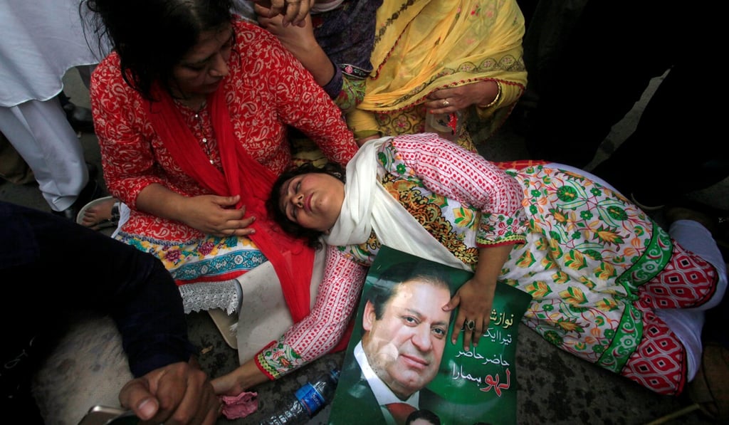 A supporter of Nawaz Sharif passes out after the Supreme Court decision to disqualify the prime minister, in his hometown of Lahore on July 28. Photo: Reuters