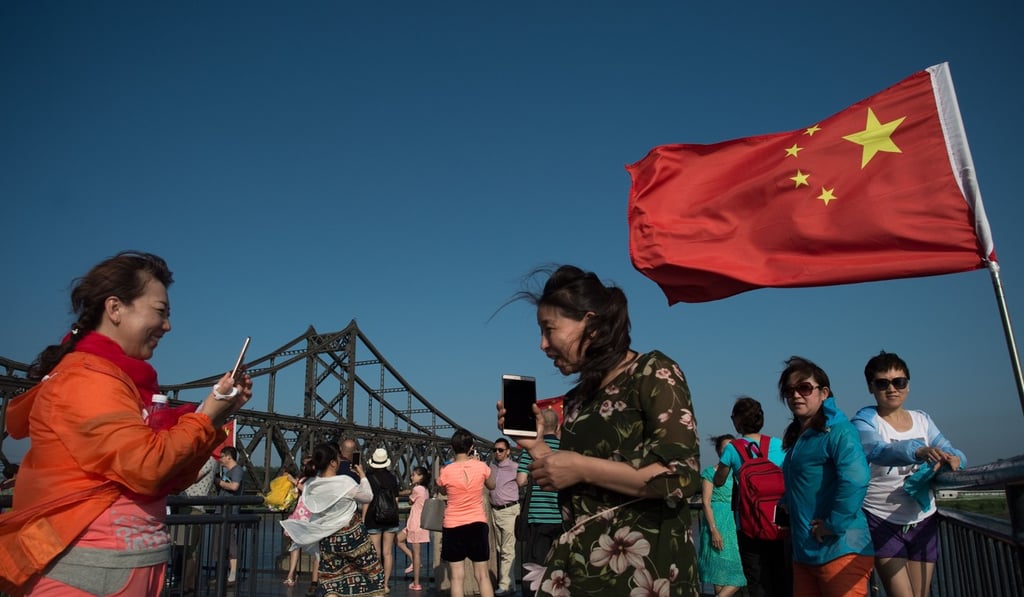 Tourists take pictures near a bridge on the Yalu River connecting the North Korean town of Sinuiju and the Chinese border city of Dandong . Rex Tillerson says North Korea is a test for the Sino-US relationship. Photo: AFP Tourists take pictures near a bridge on the Yalu River connecting the North Korean town of Sinuiju and the Chinese border city of Dandong . Rex Tillerson says North Korea is a test for the Sino-US relationship. Photo: AFP