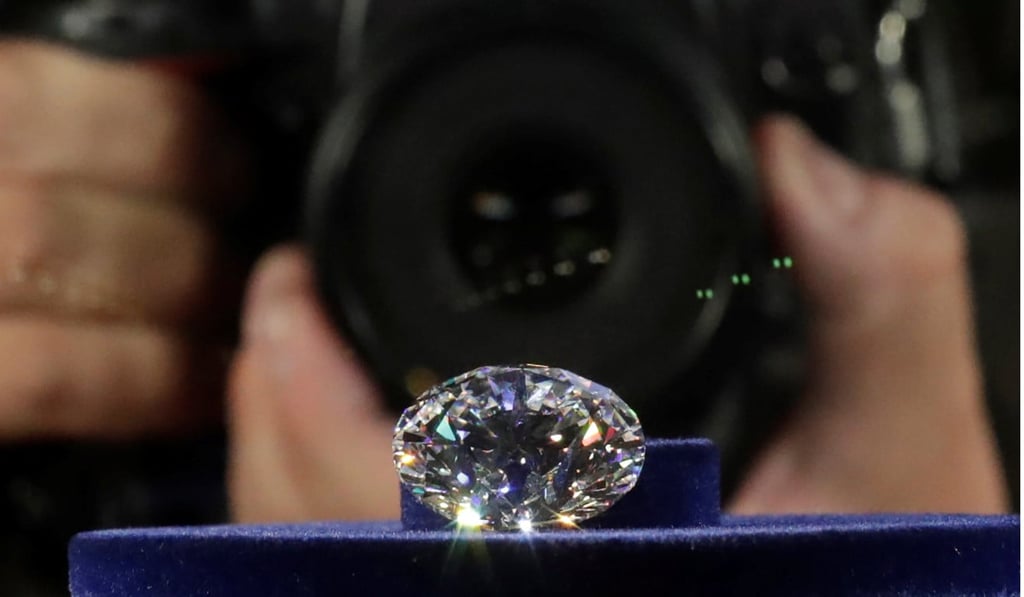 A photographer takes a picture of the main 51.38-carat diamond on display during Russian miner Alrosa's presentation of the Dynasty polished diamonds collection in Moscow, Russia. Photo: REUTERS
