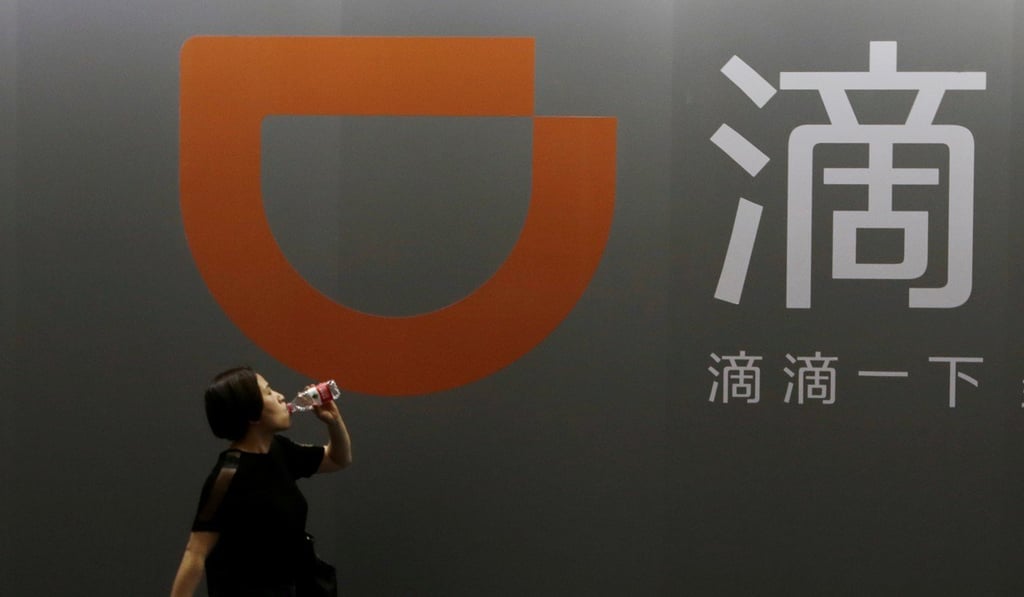 A woman walks past Didi Chuxing's booth at the Global Mobile Internet Conference in Beijing in April. Photo: Jason Lee