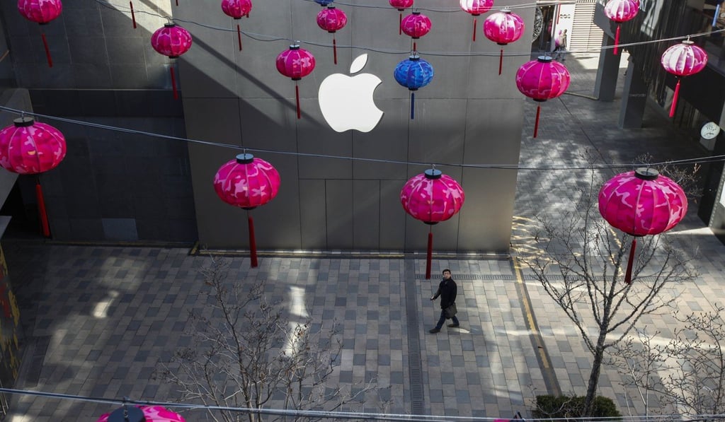 A Chinese man walks past a facade of an Apple Store amidst Chinese lantern decorations at a shopping district in Beijing, China. Photo: EPA