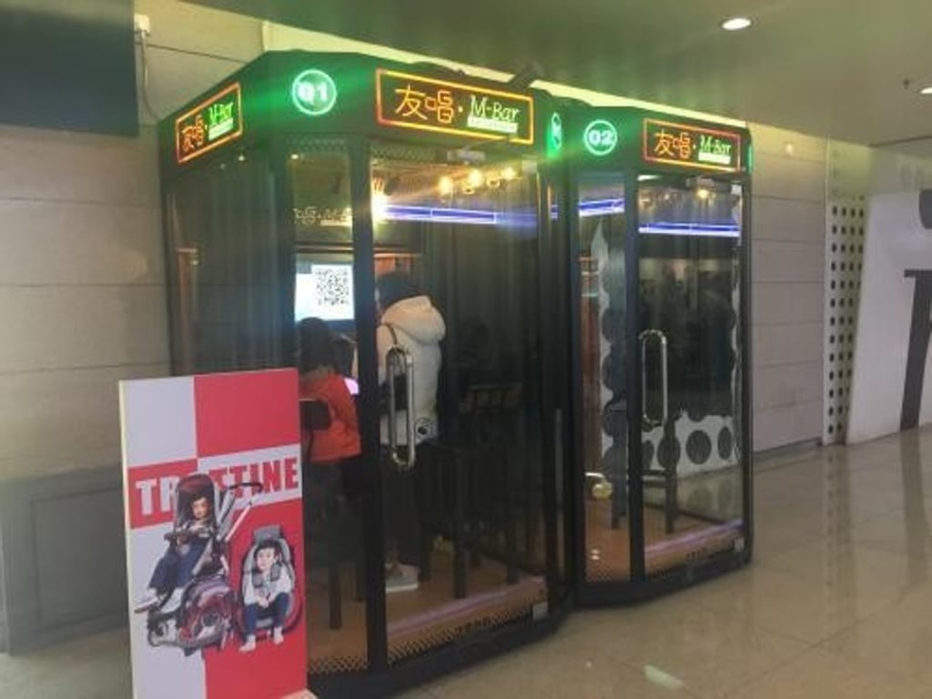 Two people inside a tiny karaoke booth on the mainland. Photo: Handout