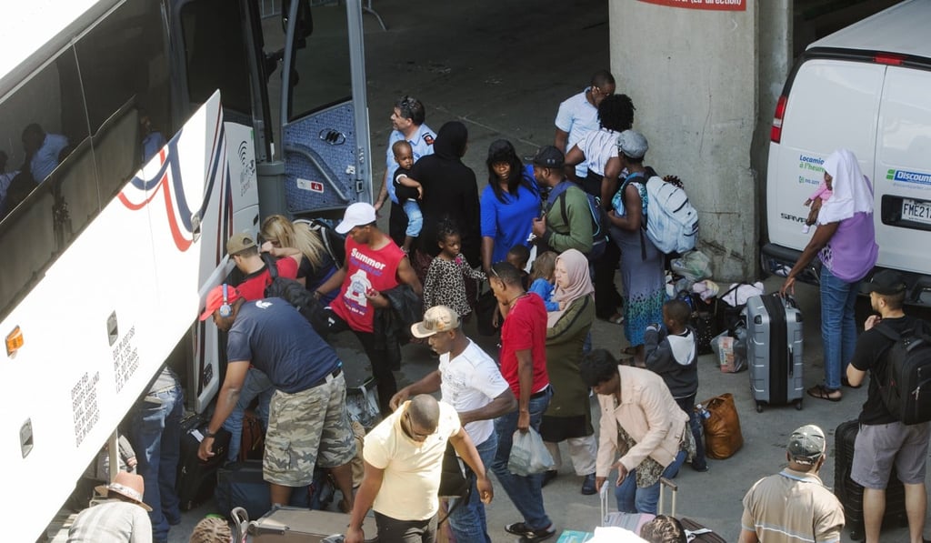 Asylum seekers collect their belongings as they arrive at Montreal’s Olympic Stadium on Wednesday. Photo: AP Asylum seekers collect their belongings as they arrive at Montreal’s Olympic Stadium on Wednesday. Photo: AP