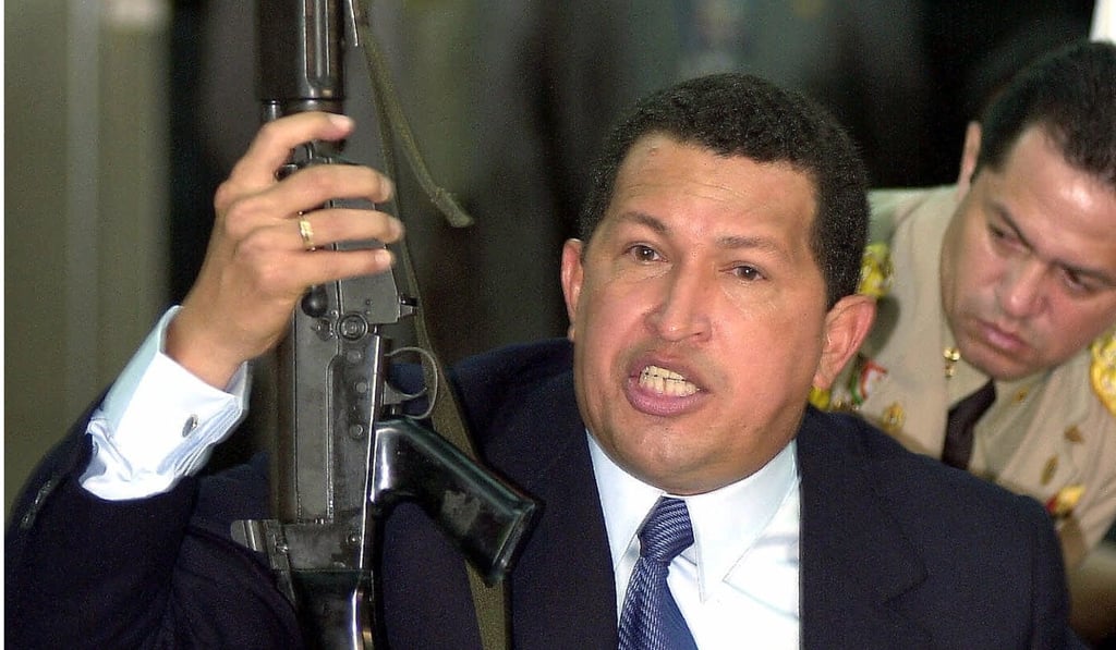 Venezuela's late former president Hugo Chaves holds up a rifle during a nationally televised press conference in Caracas in 2000. Photo: AP