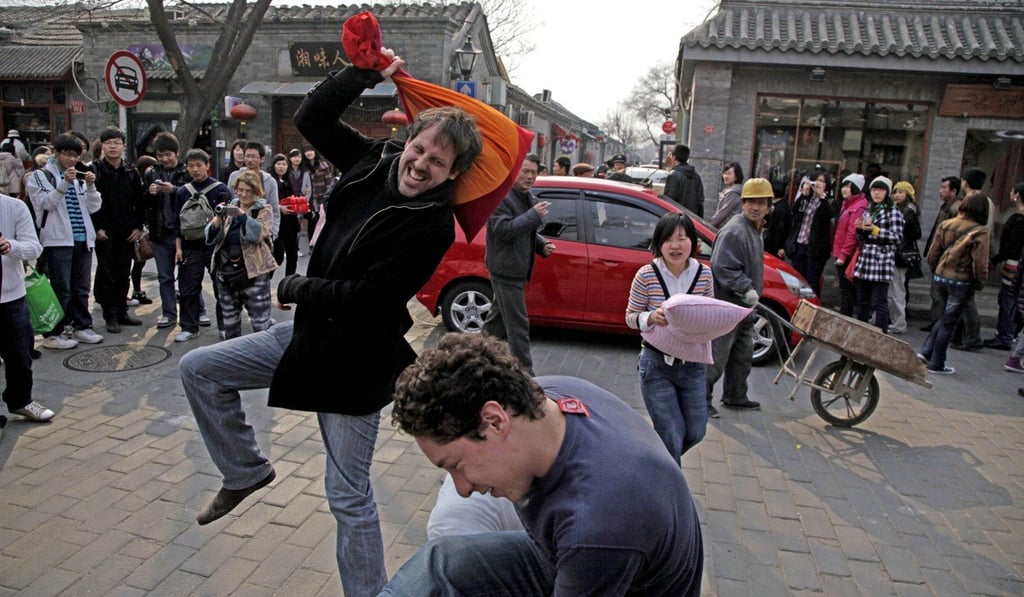 Foreigners take part in a pillow fight at a popular tourist district in Beijing. Photo: AP