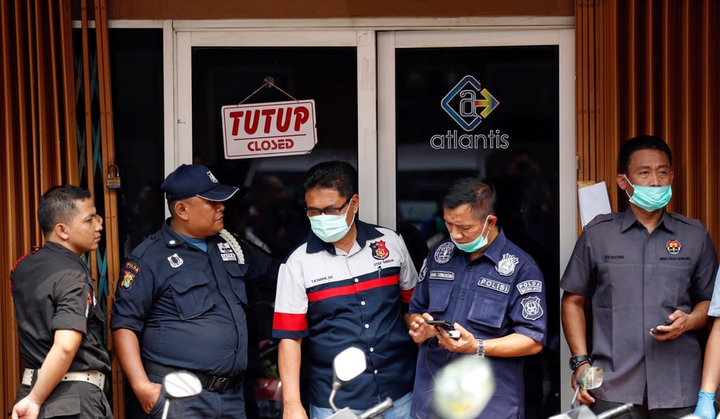 Police and security personnel wait outside a club where police detained 141 men for what they described as a gay prostitution ring in Jakarta, Indonesia. Photo: Reuters