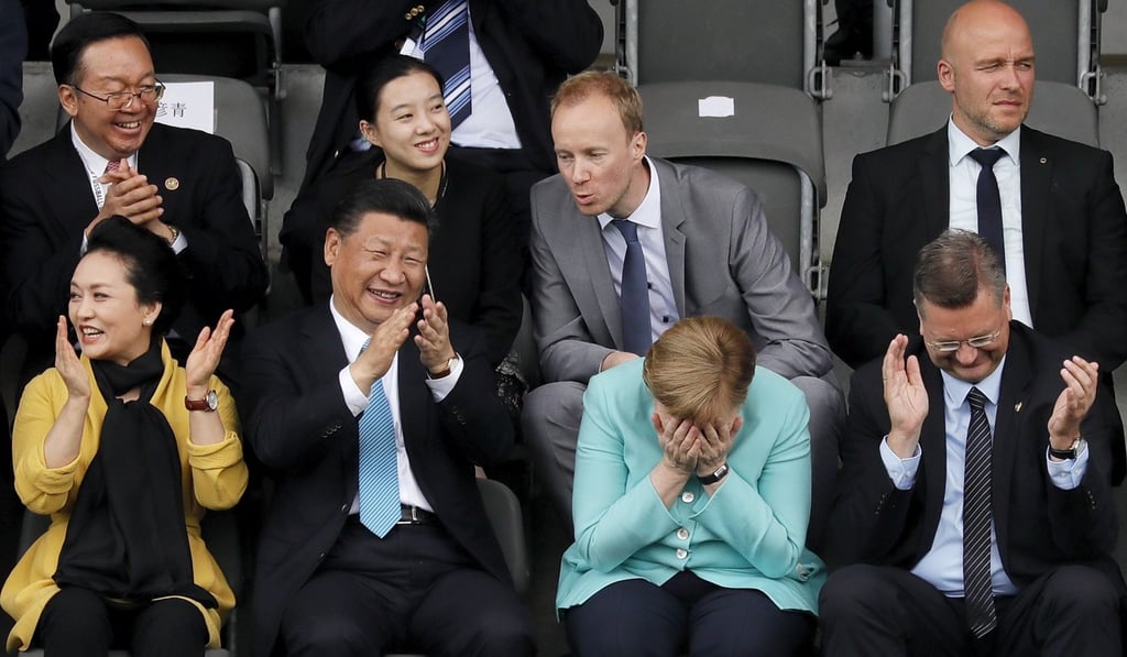 Chinese President Xi Jinping (second left) and German Chancellor Angela Merkel (third left) watch a children’s game in Berlin. Photo: EPA