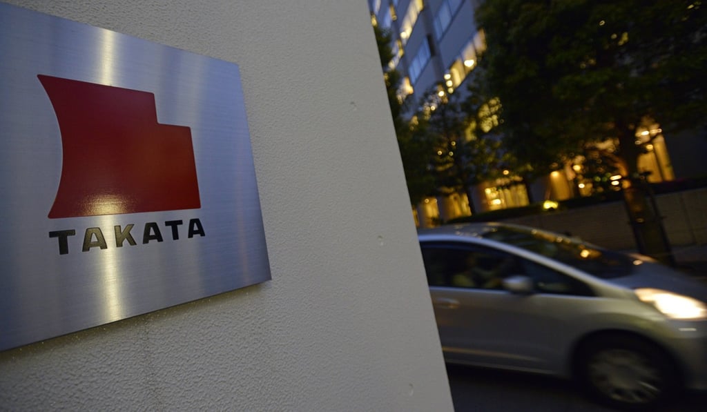 A car passes past the logo of Japanese auto-parts supplier Takata Corp in Tokyo. Photo: EPA