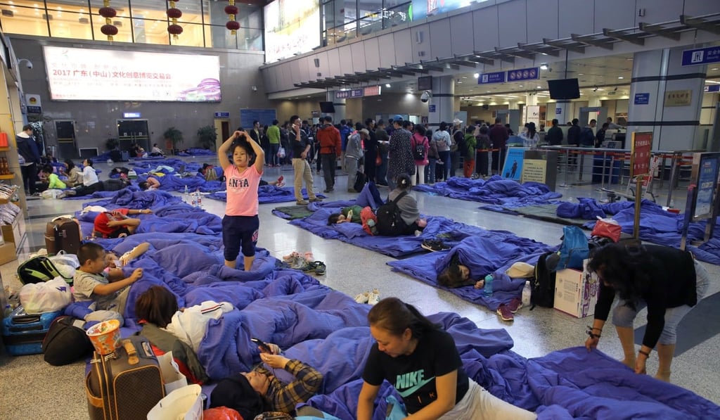 Passengers camp out at the Jiuzhai Huanglong Airport on Wednesday night as they wait for flights out. Photo: Sam Tsang