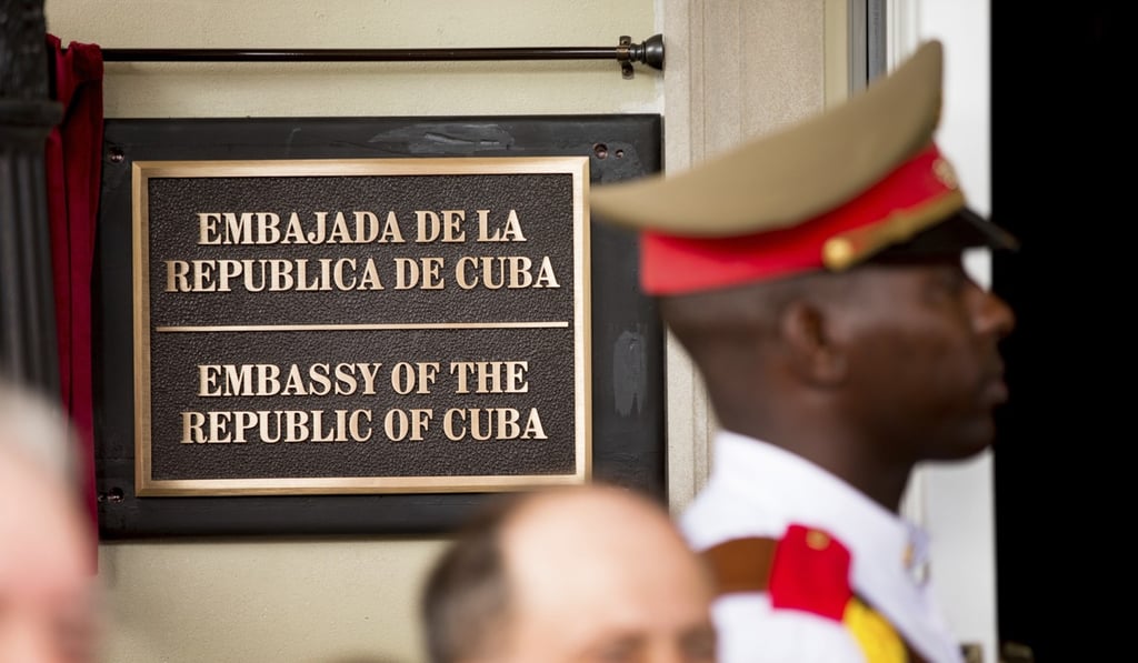 A member of a Cuban honour guard stands next to a plaque at the front door of the Cuban embassy in Washington. Photo: AP A member of a Cuban honour guard stands next to a plaque at the front door of the Cuban embassy in Washington. Photo: AP