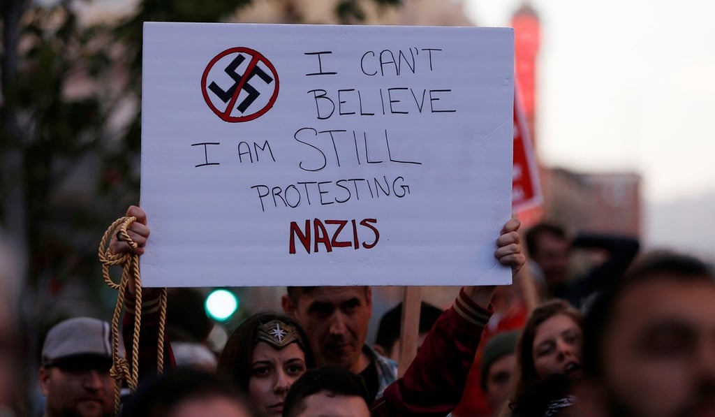 A demonstrator holds signs during a rally in Oakland responding to the Charlottesville violence. Photo: Reuters