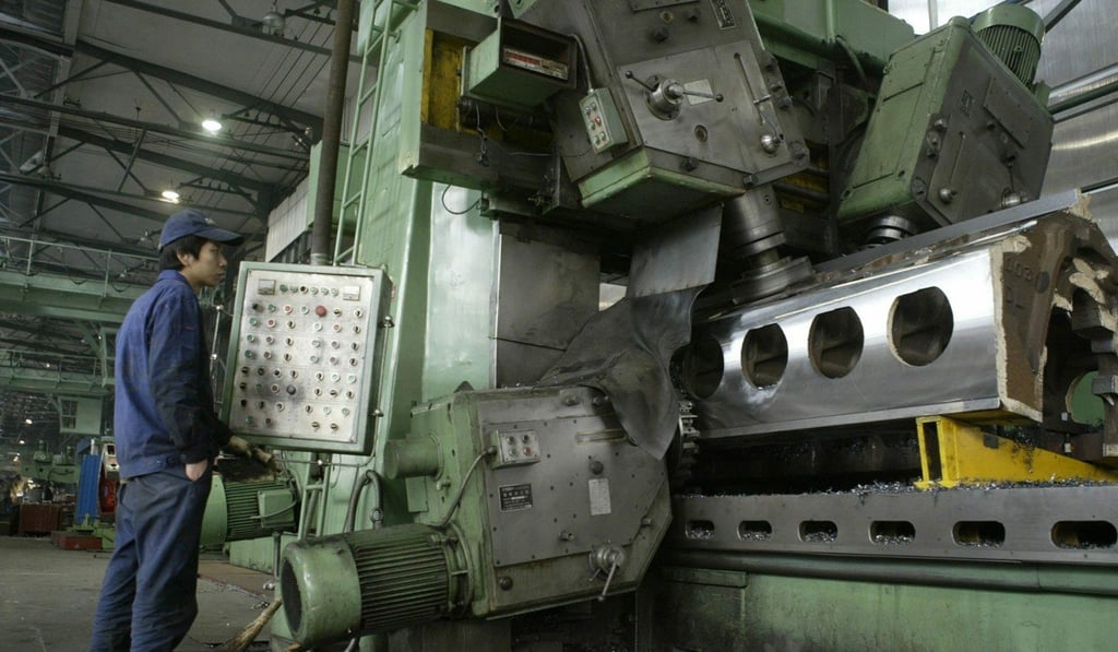 A worker operates machinery on parts used to assemble locomotives at the Dalian Locomotive and Rolling Stock Works (DLoco) factory in northern China's Dalian. The company exports to nine countries including North Korea. Photo: EPA