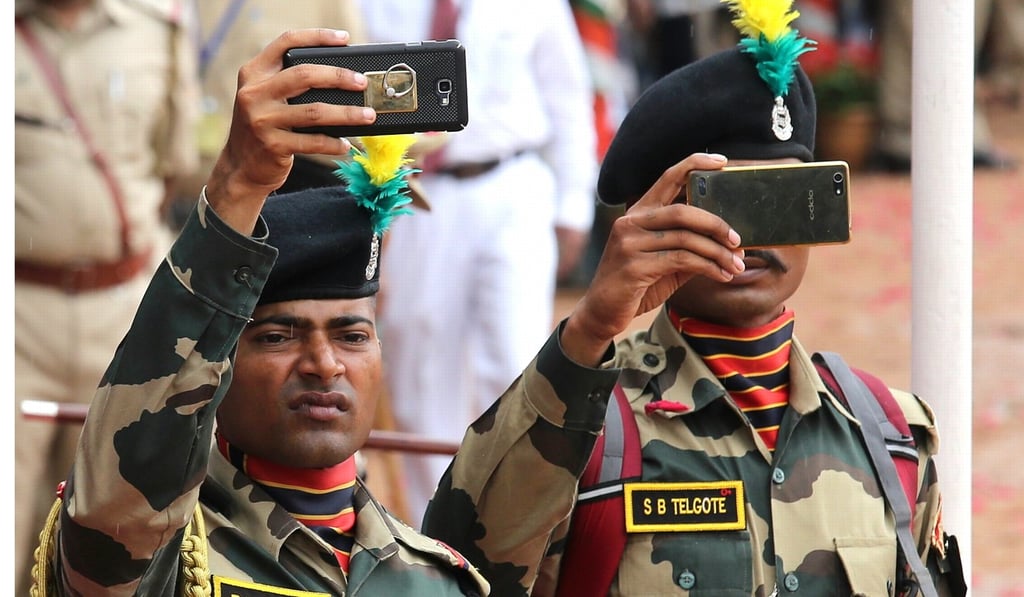 Indian army personnel take photos on their mobile phones during Independence Day celebrations in Bangalore. Photo: EPA Indian army personnel take photos on their mobile phones during Independence Day celebrations in Bangalore. Photo: EPA