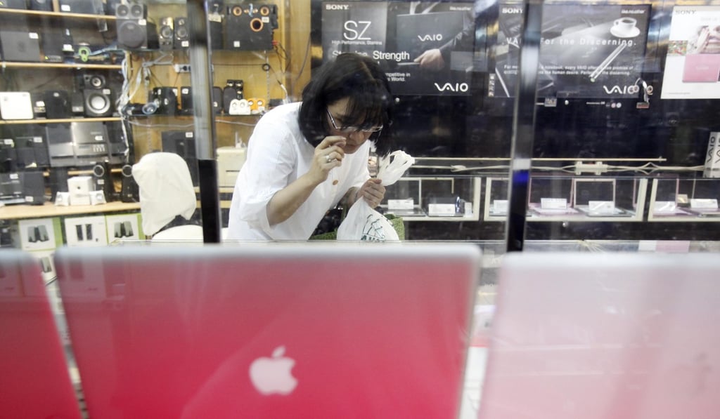 A shopper studies laptops in the electronics department of a mall in Singapore. Photo: AP