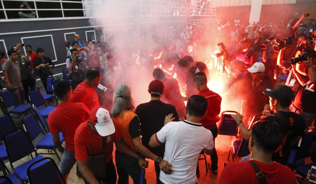 Mahathir Mohamad narrowly missed being hit by flares, chairs, slippers and water bottles at the town hall meeting in Shah Alam on Sunday. Photo: AP