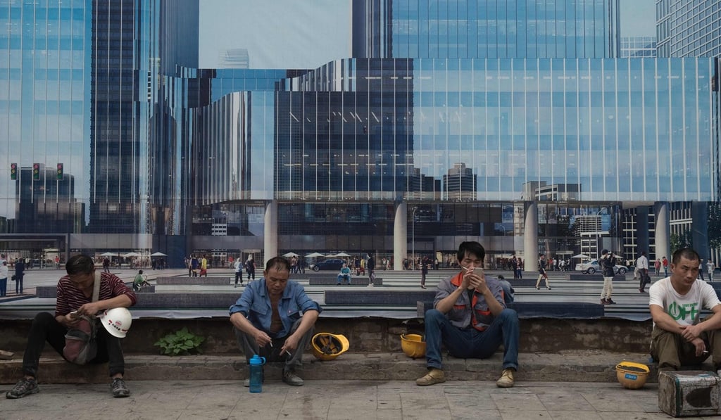 Construction workers take a break outside a building site in Beijing on Tuesday. China continues to hit its growth target, but fears over debt remain. Photo: AFP Construction workers take a break outside a building site in Beijing on Tuesday. China continues to hit its growth target, but fears over debt remain. Photo: AFP