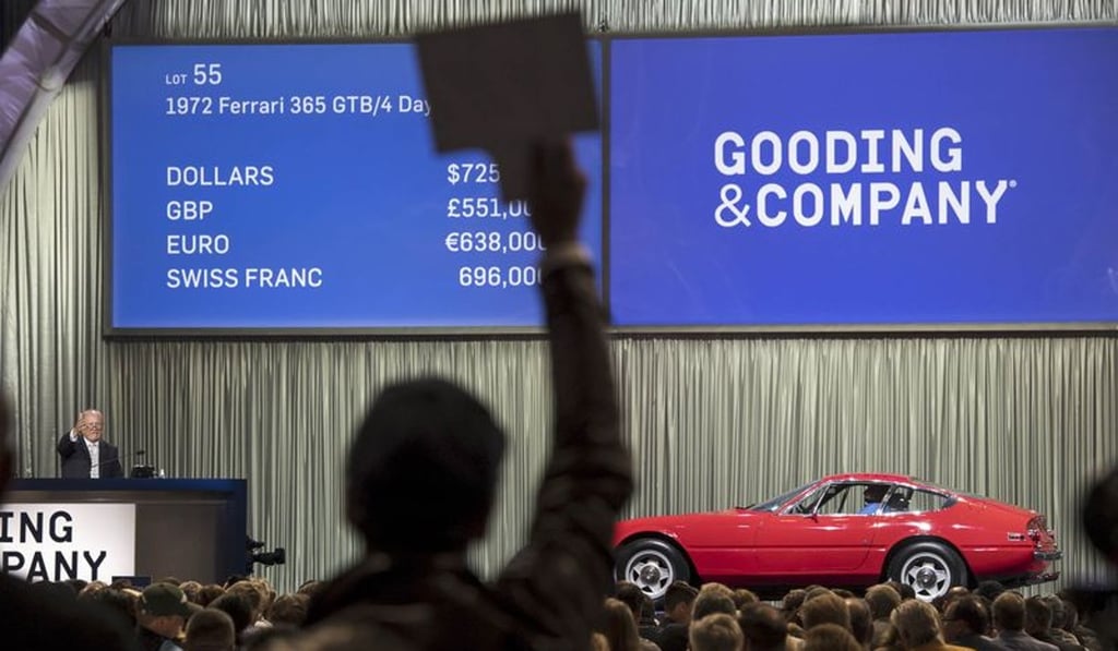An attendee places a bid for a 1972 Ferrari SpA 365 GTB/4 Daytona vehicle during the Gooding & Co. auction at the 2016 Pebble Beach Concours d’Elegance in Carmel, California.