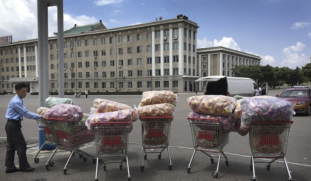 A man waits with shopping carts in front of a department store in Pyongyang. Photo: AP A man waits with shopping carts in front of a department store in Pyongyang. Photo: AP