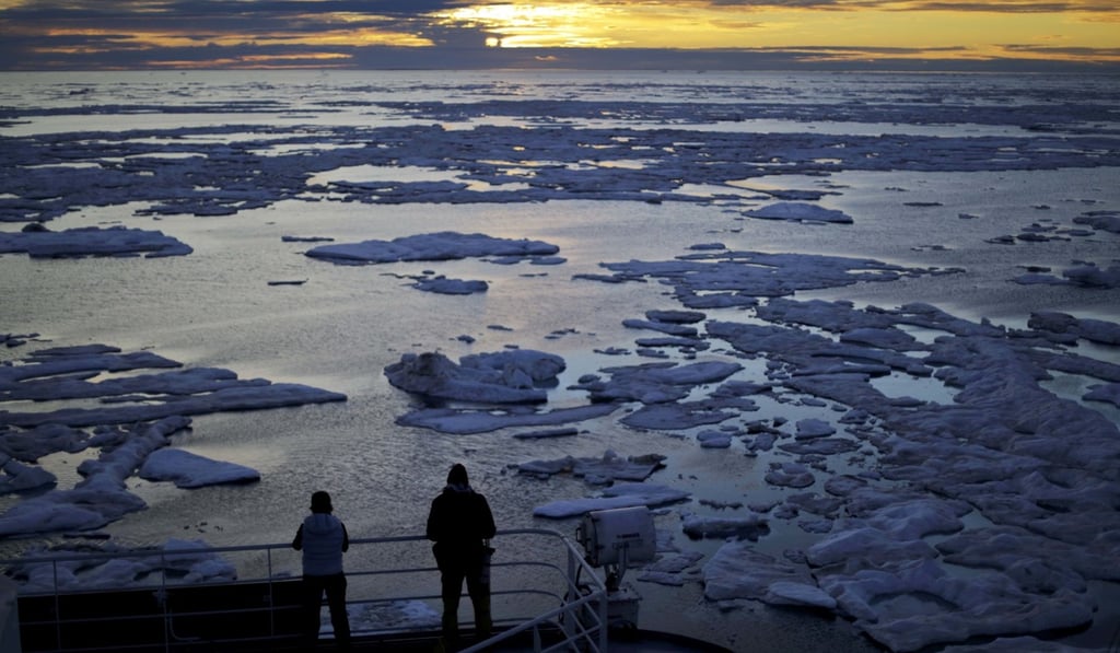 Researchers look out from the Finnish icebreaker MSV Nordica as the sun sets over sea ice floating on the Victoria Strait along the Northwest Passage in the Canadian Arctic Archipelago. Studies show the Arctic is heating up twice as fast as the rest of the planet. Scientists are concerned because impacts of a warming Arctic may be felt elsewhere. Photo: AP