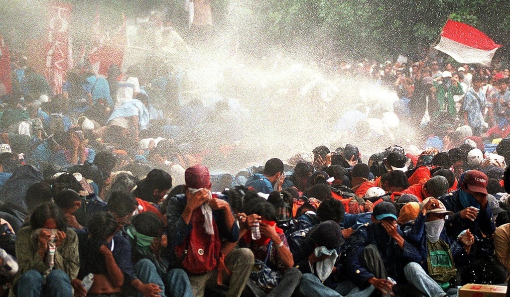 Indonesian students are sprayed with a water cannon during a protest against Suharto. Photo: AFP