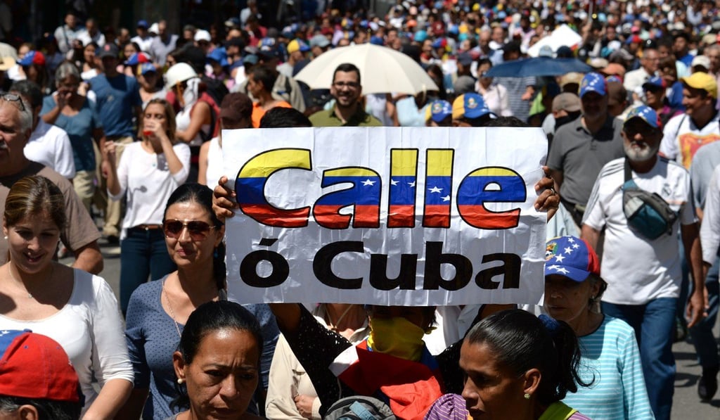 Venezuealan anti-government activists hold a sign reading “Street or Cuba”, mocking President Nicolas Maduro’s close ties to Havana, during a protest in Caracas on August 4. Photo: AFP Venezuealan anti-government activists hold a sign reading “Street or Cuba”, mocking President Nicolas Maduro’s close ties to Havana, during a protest in Caracas on August 4. Photo: AFP