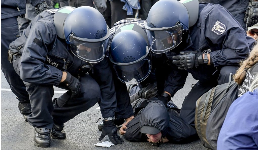 Police detain a counter-protester for blocking a street to try to stop the far-right rally. Photo: EPA Police detain a counter-protester for blocking a street to try to stop the far-right rally. Photo: EPA