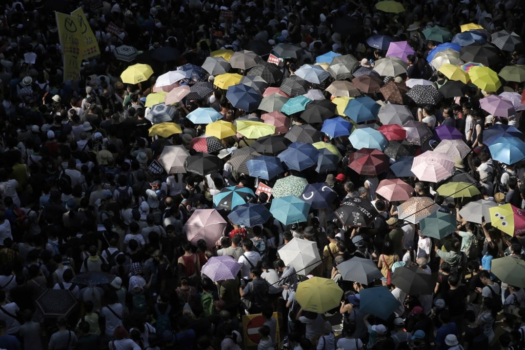 Crowds took to the streets in Wan Chai to protest against recent court rulings on activists. (AP Photo/Kin Cheung) Crowds took to the streets in Wan Chai to protest against recent court rulings on activists. (AP Photo/Kin Cheung)
