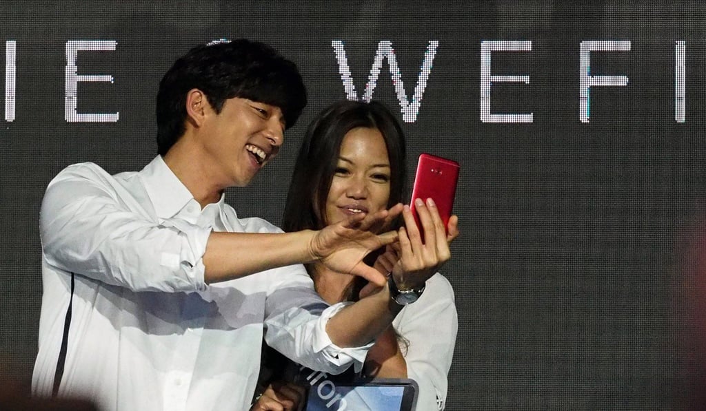 Gong Yoo takes selfie with a fan as he attends a news conference launching ZenFone 4 smartphone. Photo: EPA