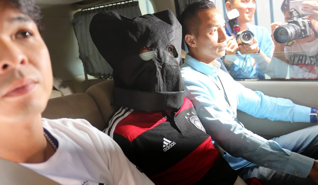 The suspect (centre) is being held for questioning. Photo: Dickson Lee