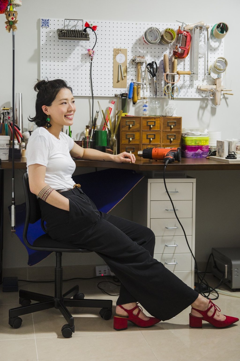Kwok wears a white T-shirt from H&M, black trousers from COS, red lace-up heels from Zara and earrings from her own designs. Photo: Michelle Wong