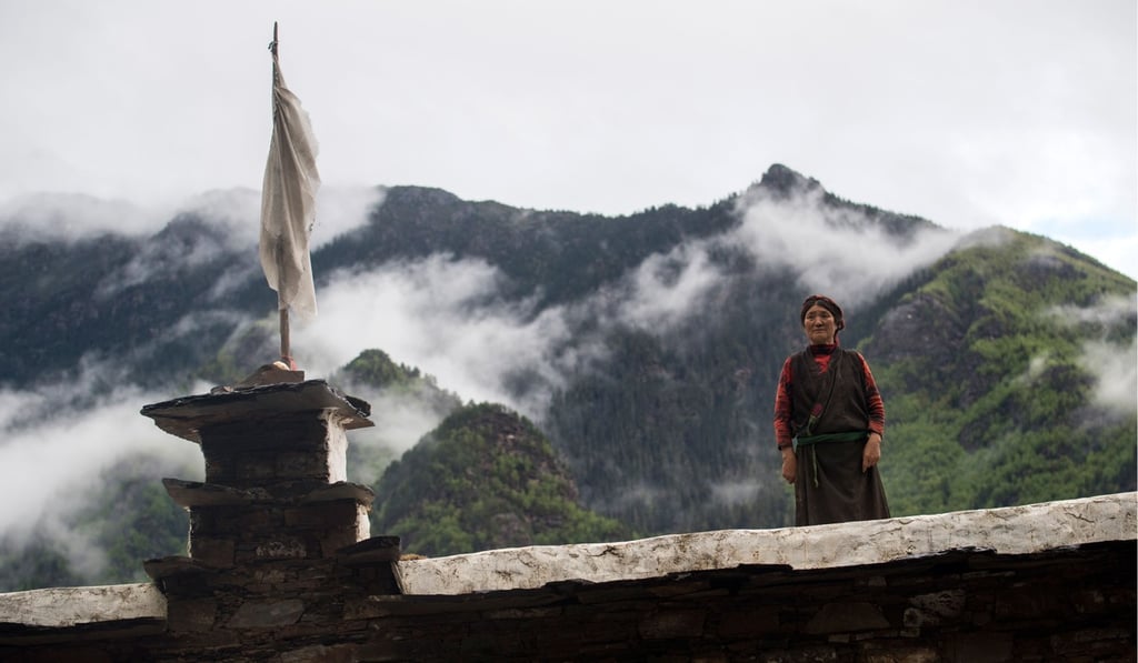 A Zhaba woman stands on the top of a traditional house. Photo: AFP A Zhaba woman stands on the top of a traditional house. Photo: AFP