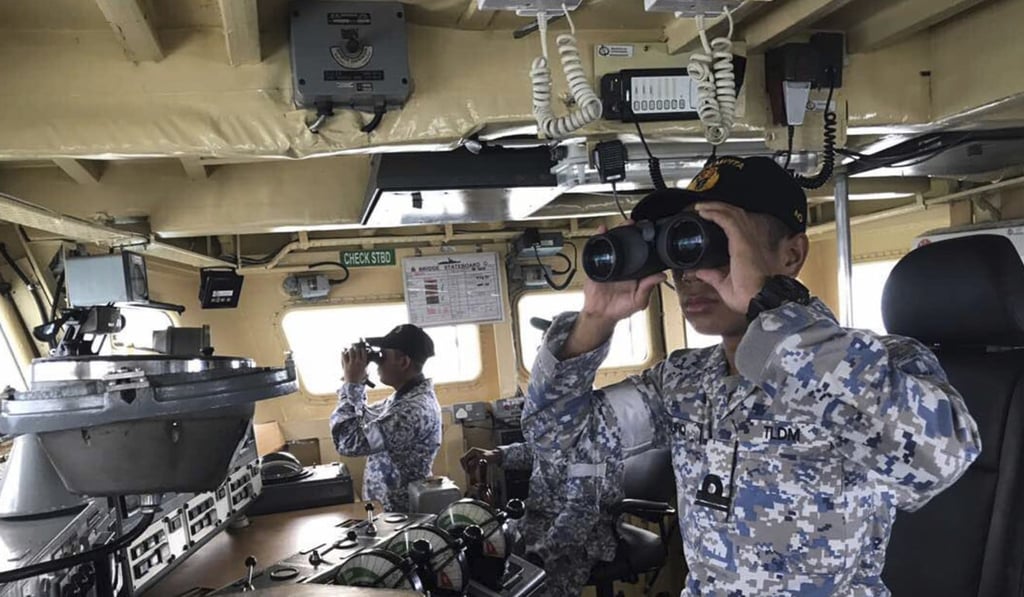 Royal Malaysian Navy personal look out for the missing sailors. Photo: AP Royal Malaysian Navy personal look out for the missing sailors. Photo: AP