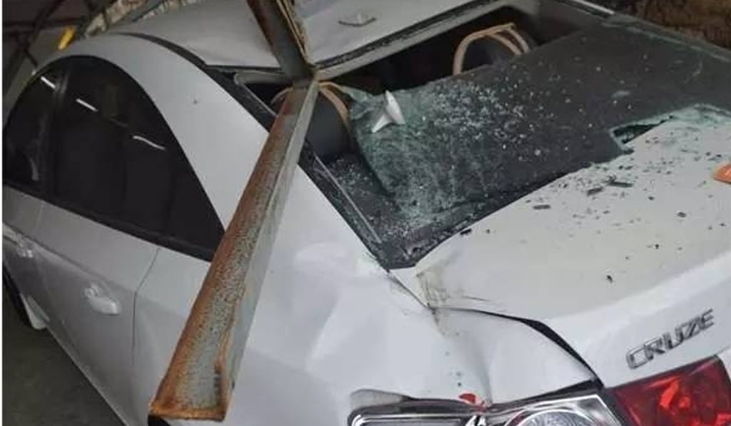 The owner of this car was just seconds away from being crushed by a huge billboard. Photo: Handout