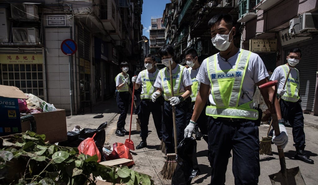 Police officers clean debris and rubbish on a street in the aftermath of Typhoon Hato. Photo: AFP