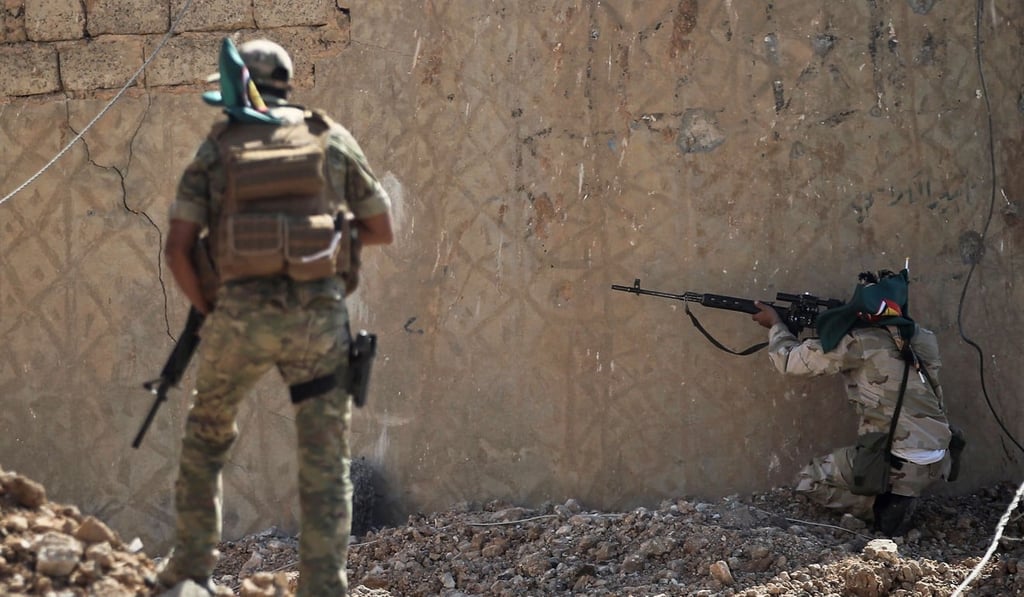 A sniper of the Hashed Al-Shaabi (Popular Mobilisation units) takes cover during the advance through the town of Tal Afar, west of Mosul. Photo: AFP