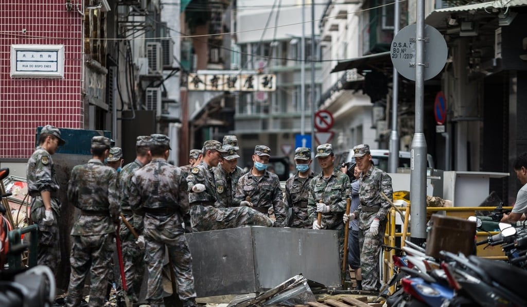 People’s Liberation Army soldiers were sent into the streets to help with recovery efforts after Typhoon Hato. Photo: EPA