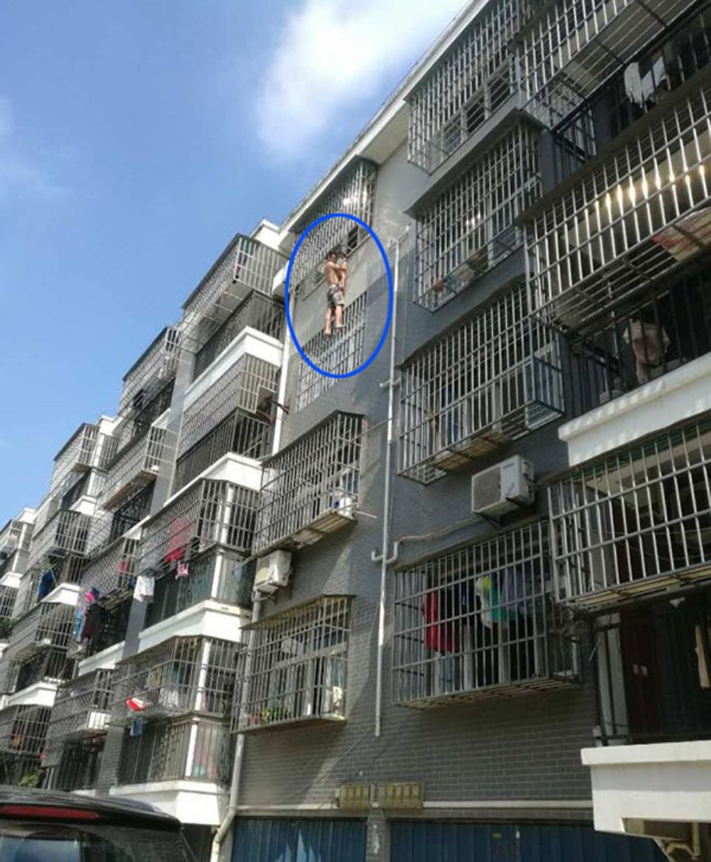 The man and girl cling to the side of the building. Photo: Handout The man and girl cling to the side of the building. Photo: Handout