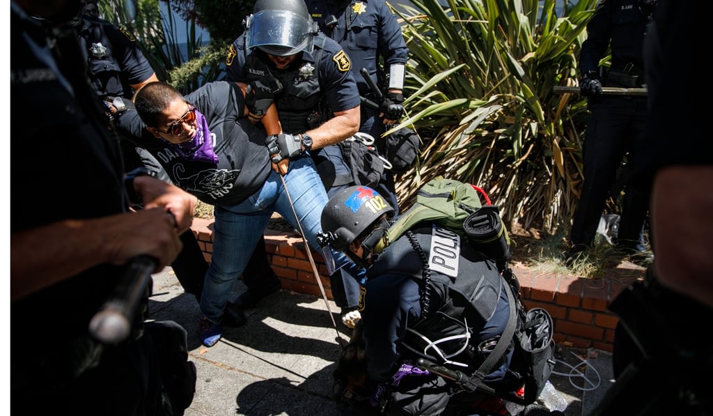 Police officers arrest a protester and her dog during a day of clashes and protest in Berkeley on Sunday. Photo: TNS Police officers arrest a protester and her dog during a day of clashes and protest in Berkeley on Sunday. Photo: TNS