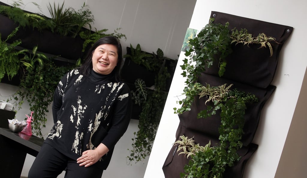 Margaret Chen Sai-man, founder of SquAIR, poses pictures with ‘living walls’ of plants at her office in Wong Chuk Hang. Photo: May Tse