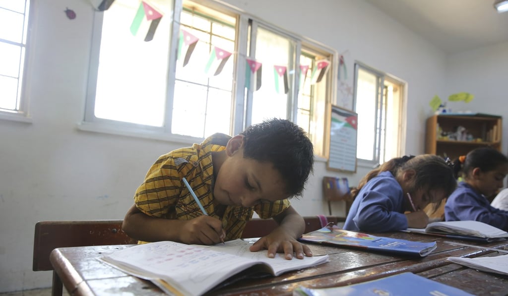 In this July 20 photo, a Syrian refugee boy takes notes during a lesson at a summer school in Amman, Jordan. Photo: AP