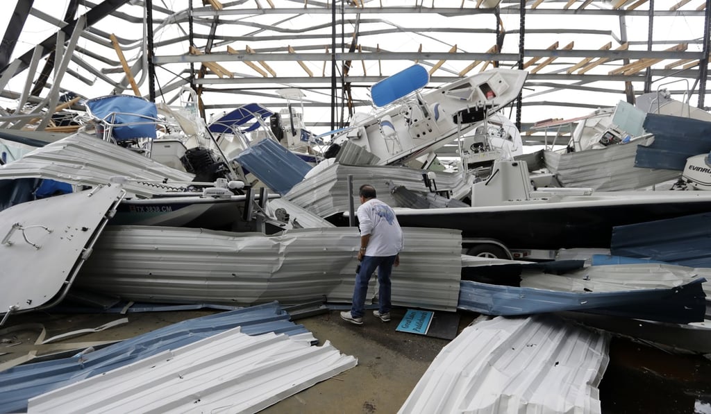 Dominic Dominguez looks through a stack of boats jumbled in the wake of Tropical Storm Harvey on Sunday in Rockport, Texas. Photo: AP Dominic Dominguez looks through a stack of boats jumbled in the wake of Tropical Storm Harvey on Sunday in Rockport, Texas. Photo: AP