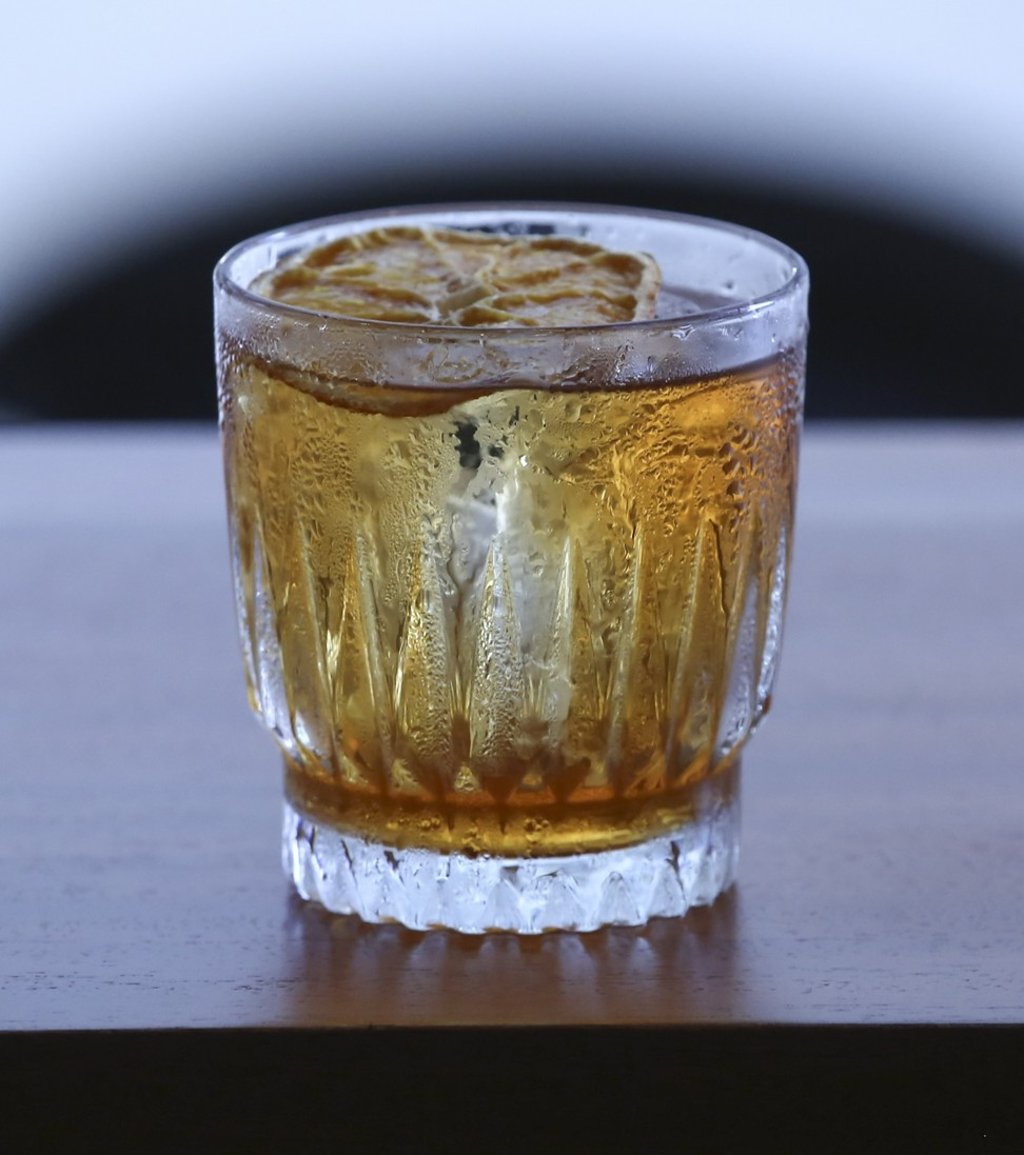 The old fashioned, a house blend of bourbon and rye whiskeys, cognac, and chocolate bitters, garnished with a slice of dried orange. Photo: Jonathan Wong