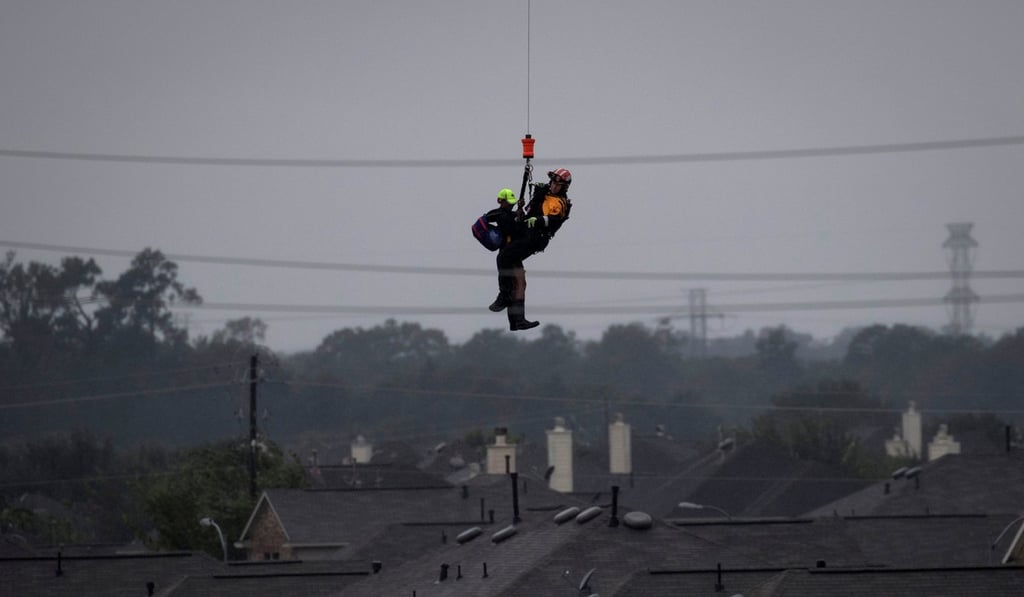 A US military helicopter and personnel rescue a stranded resident from floods caused by Tropical Storm Harvey in east Houston. Photo: Reuters